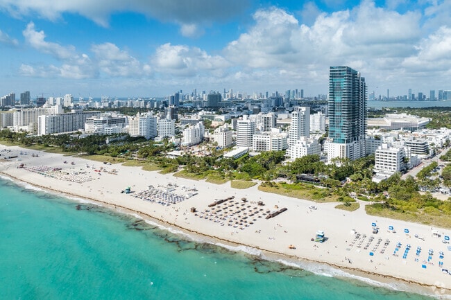 The beach at Miami Beach Boardwalk has white sand and crystal-clear water.