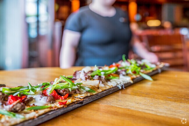Seasons 52 is known for its signature Philly Cheesesteak Flatbread in Swanston Estates.