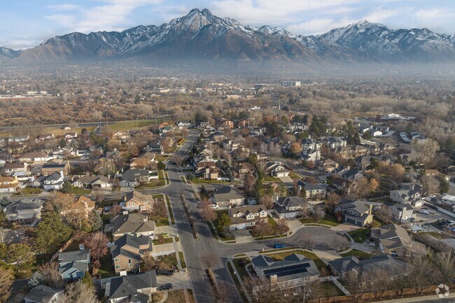 An aerial view of Holladay shows large homes amidst mature trees by the mountains.