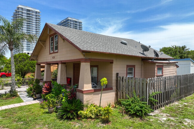 Traditional single family home with front porch and surrounding garden in North Palm Beach.