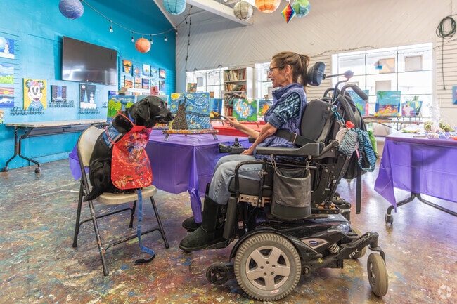 A woman and her service dog enjoy a special moment painting at CD's Art Studio in Kooser.