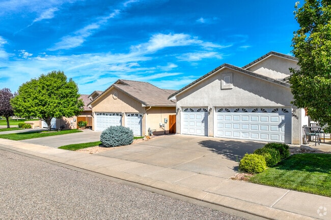A row of uniform ranch homes with two-car garages and stucco roofing in Regency, Sunny Heights.