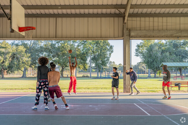 Debaillon Park youths enjoy a game of basketball under a covered basketball court.