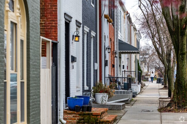 Neighborhood streets in Selwyn Famrs are lined with flat front townhomes, painted in bright colors.