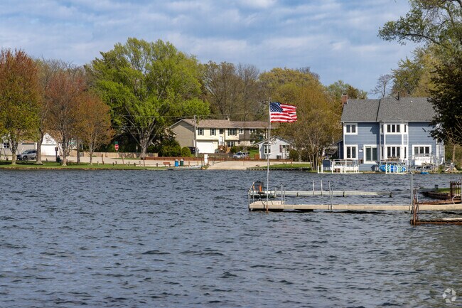 An American flag waves beside lakefront homes and docks along the shoreline of Gages Lake.