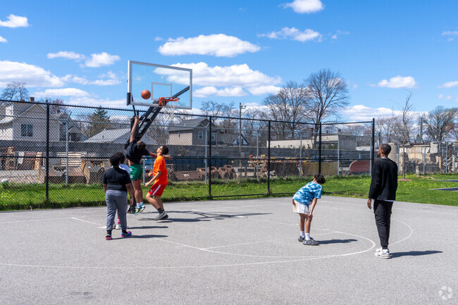 Local children play basketball at Samuel Bolden Park in Upper Hill.
