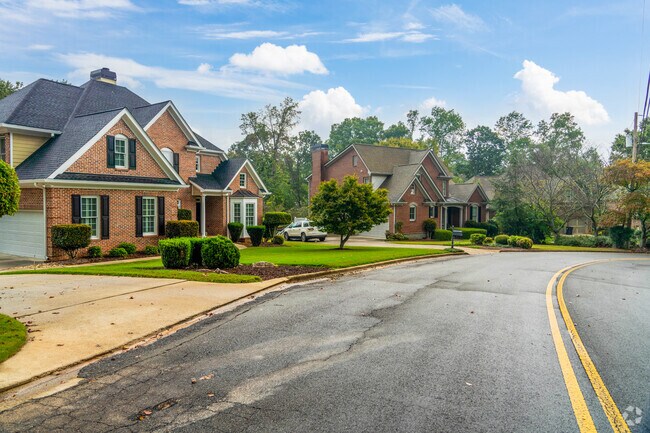 A row of estate style homes in Bradford-Ridgewood have grassy lawns with attached garages.