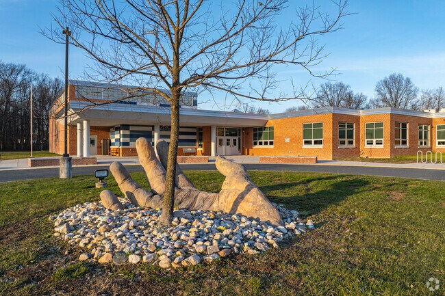 A statue of a hand rising from the ground can be found in front of Perryville Elementary School.