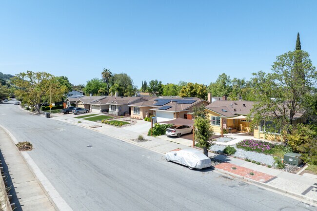 Well-kept Midcentury Ranch homes with neat lawns and wide driveways line this Hidden Glen South street.