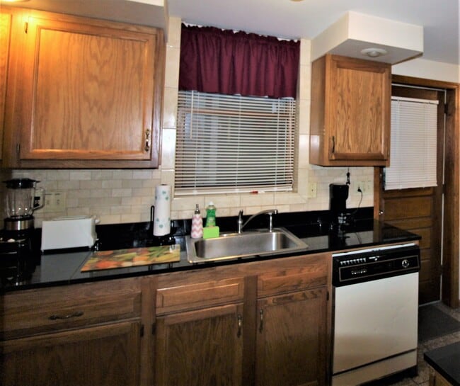 Kitchen with dishwasher and granite countertops