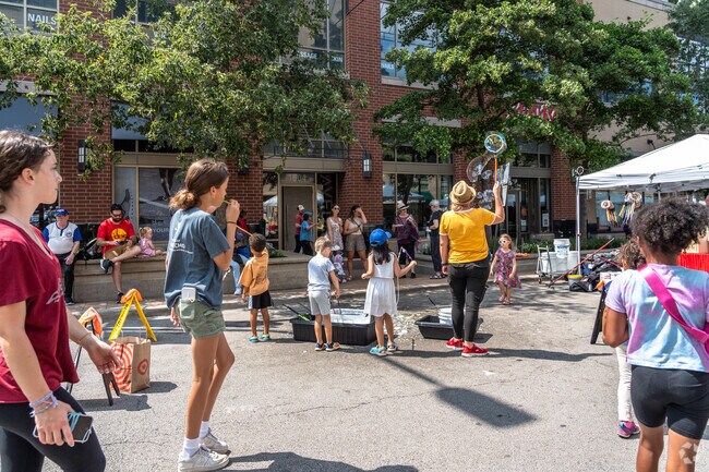 Kids play with giant bubble wands during the Art and Big Fork Festival in Downtown Evanston.