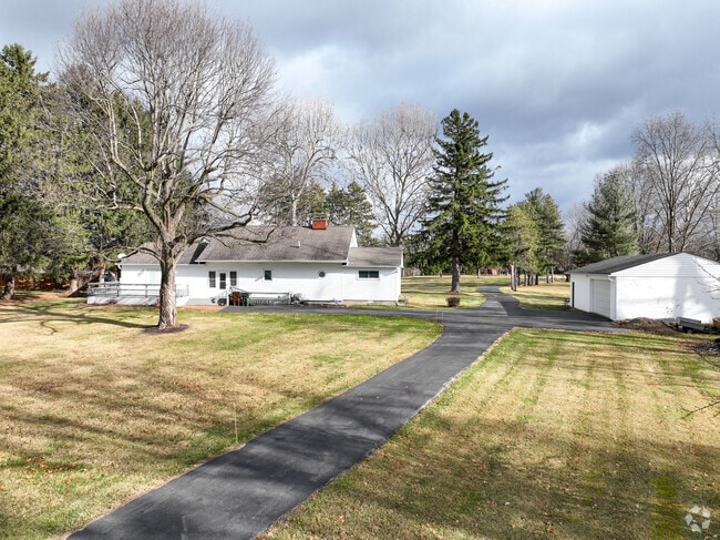 A white farmhouse with a detached garage in Radnor, Ohio.