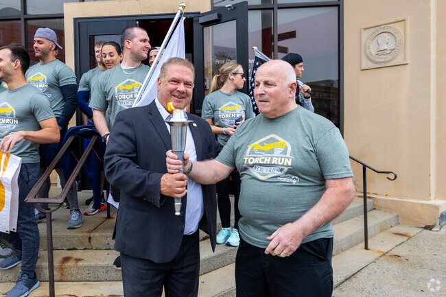 The torch is lit and handed off to one of the runners at the Yonkers 3rd precinct.