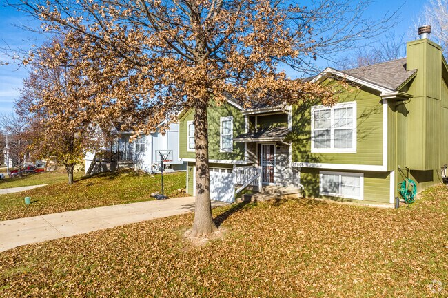This split-entry home features a bright, welcoming exterior with wide front steps and a shaded yard, offering a classic suburban look.