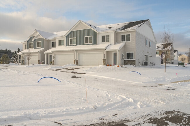 Snow-covered duplex property in Zimmerman, Minnesota, offering spacious living and a peaceful neighborhood backdrop.