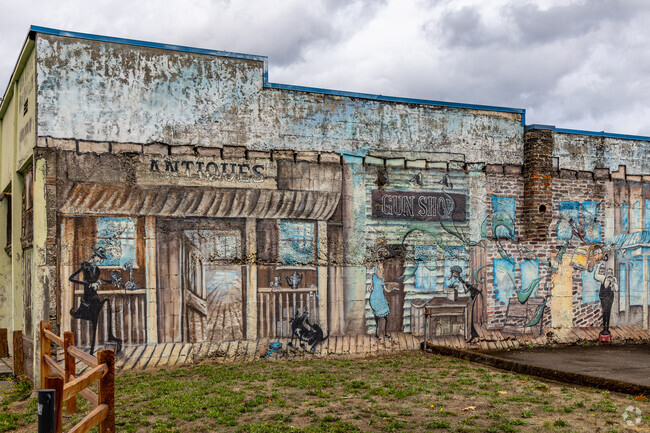 A well worn mural on an older commercial building depicts historic Oak Grove.