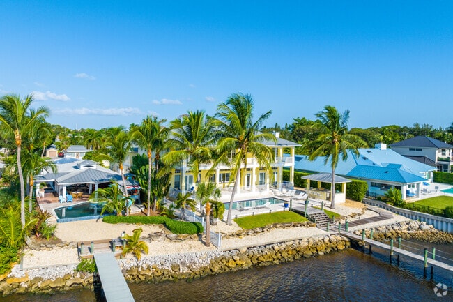 Row of riverfront homes with private pools and boat docks.
