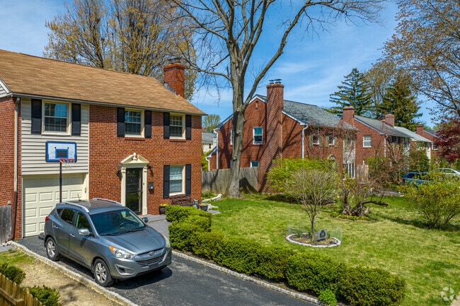 Two-story brick colonials sit on leafy green streets with private parking in Ardmore.