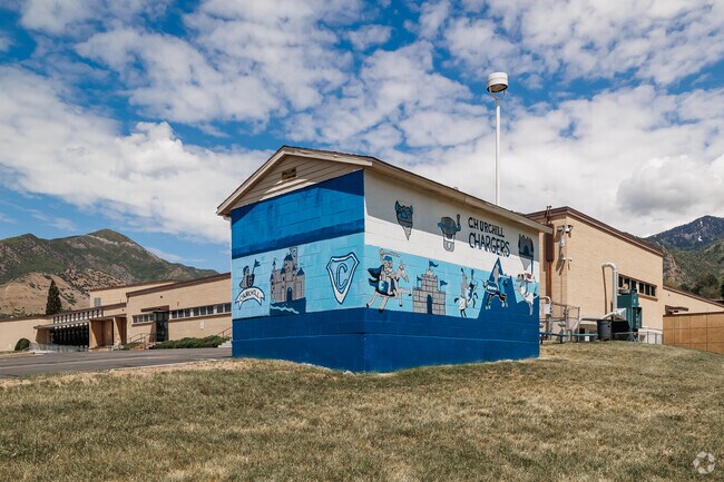 A shed at Churchill, painted with a mural depicting images with the school colors and mascot.