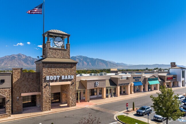 An American flag waves next to the clock tower above shops at Jordan Landing.