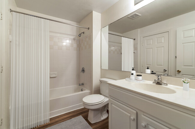 Renovated Package II bath with white cabinetry, white granite countertops, and hard surface plank flooring