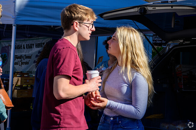 A couple discuss making a purchase at the Lafayette Farmer's Market, a short walk from Perrin.