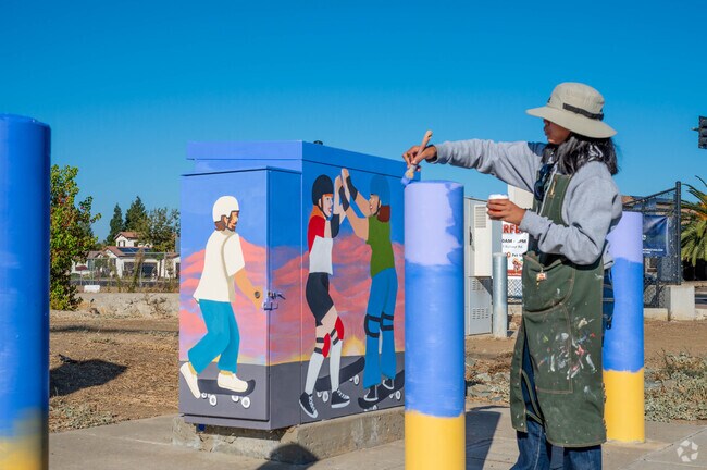 Lone Tree Valley local paints a mural on the electrical boxes.