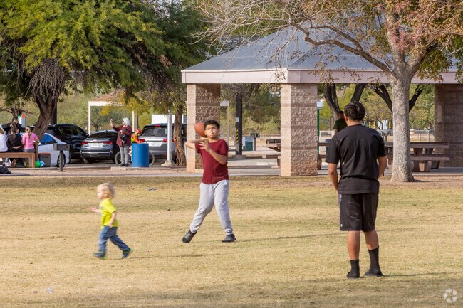 Two kids throw a football back and forth at Tucson’s Udall Park.