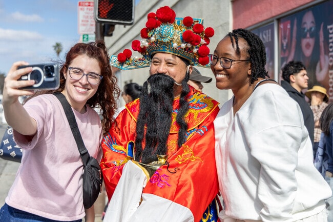 Visitors capture the moment with a selfie alongside a costumed performer at Alhambra’s Lunar New Year celebration.