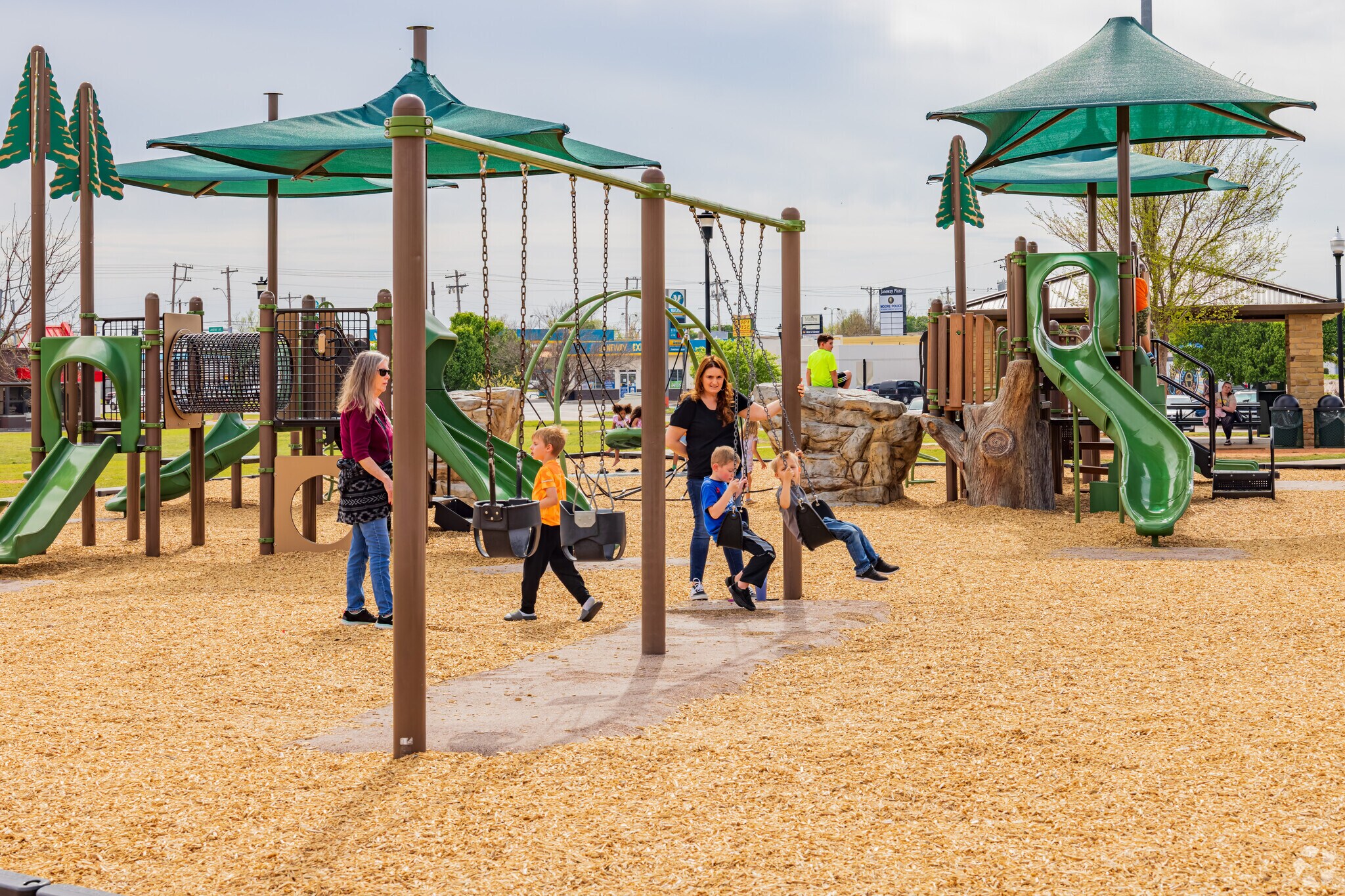 Kids enjoy playing the swings in the playground of Parmele Park.