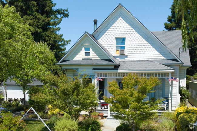 In Fulton, California an old victorian is adorned with an American Flag on a summer day.