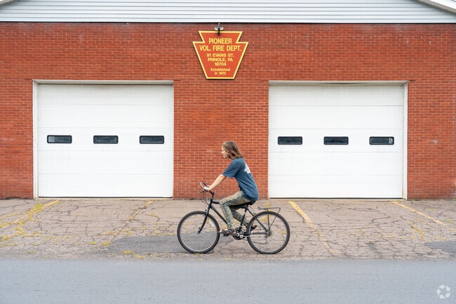 Residents in Pringle ride their bicycles by the Pioneer Volunteer Fire Department.