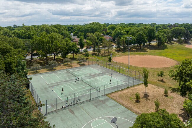 People playing in the tennis courts in Armatage Park.