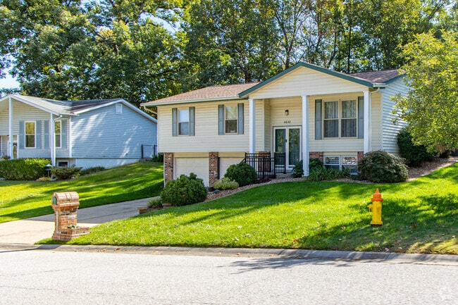 Bi-level homes line quiet streets with well-maintained lawns in Harvester, Missouri.