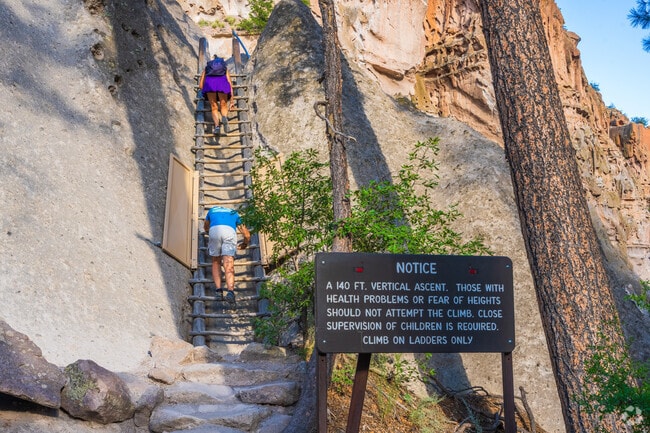 Ancient pueblo ruins carved into cliffs at Bandelier National Monument near El Rancho.