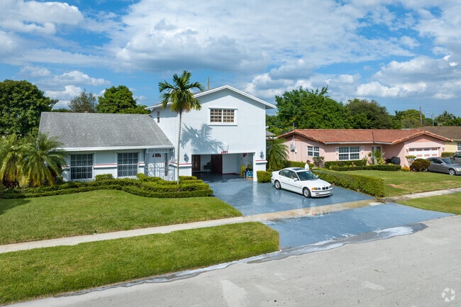 A row of homes in Lauderhill in Ft Lauderdale with people out washing their cars.