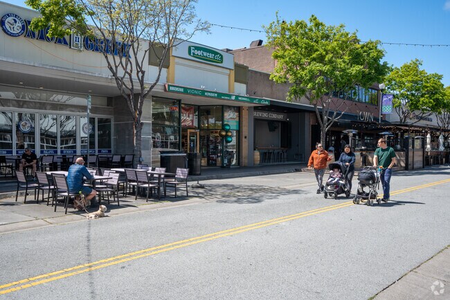 Families stroll along Laurel Street next to Alder Manor with kids in tow.