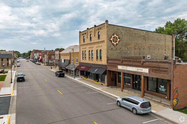 The Montgomery downtown area features historic brick buildings, vintage signage, and family-owned shops creating an old-fashioned town center atmosphere in this rural Minnesota community.