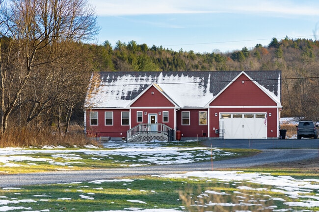 This charming red home in Westford, is a modern ranch-style design, featuring a long single-story layout, a wide front façade, and an attached garage that blends practicality with classic country appeal.
