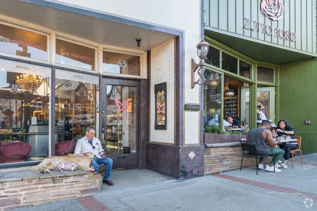 A man kicks back with his dog in front of a storefront in Old Town Los Gatos.