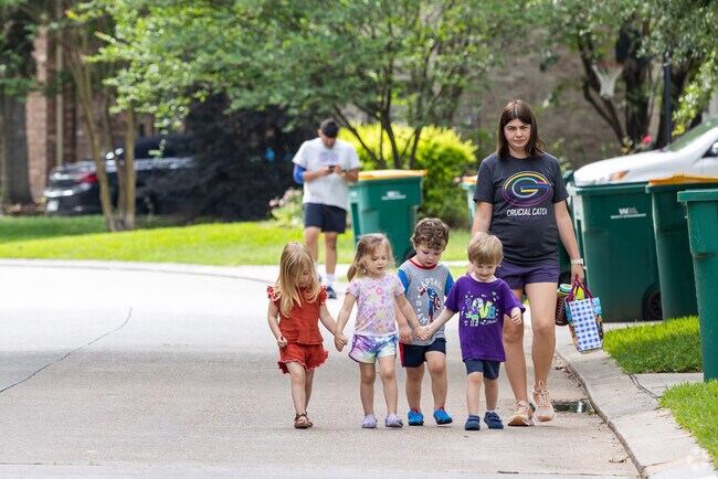 A young mother guides a group of children to a nearby park in Harper's Landing.