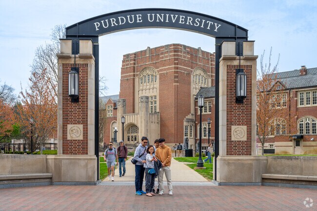 A family takes a selfie at the Purdue University archway just up the road from Cross Point.