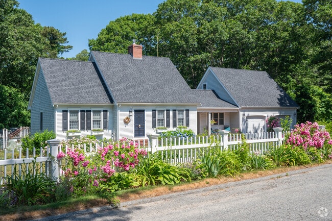 Bright pink beach roses are an ideal complement to this Cape Cod home in Bourne.