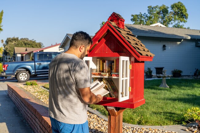 A man finds a new read in the Little Free Library, a cozy feature of Miner.