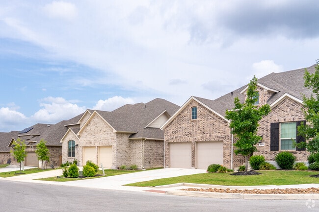 Modern brick-finished homes line the street in Fronterra at Westpointe, showcasing sleek style and family-friendly design.