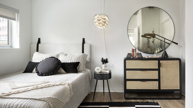 Spacious apartment bedroom with wood floors.