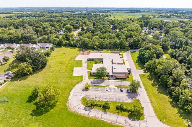 The multi-use field at Winkler Elementary School is surrounded by large mature trees.