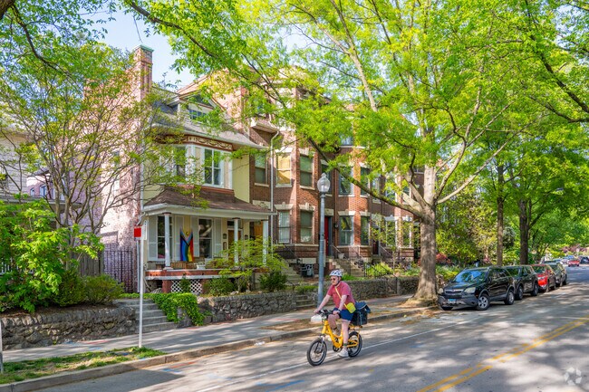 An Italianate row home next to a brick condo complex on Kenyon St NW in Mount Pleasant.