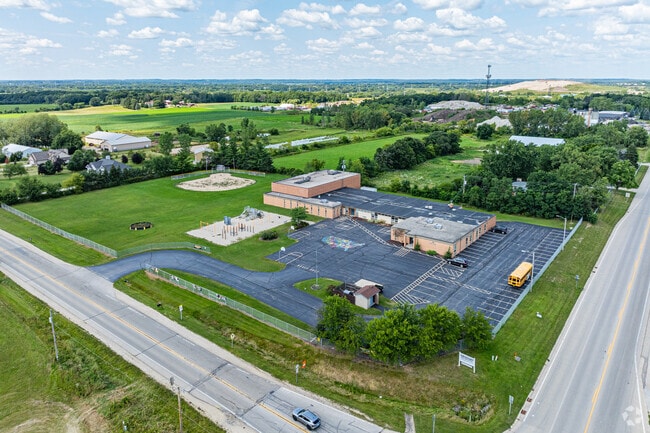 A large open field and baseball diamond sit behind the Drought Elementary School.