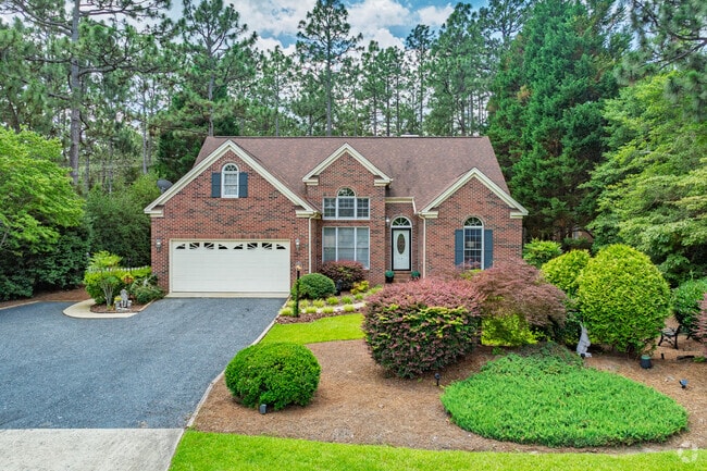 A manicured lawn frames this brick colonial in the heart of Pinehurst, North Carolina.